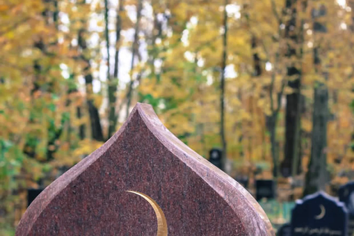 Tombe musulmane avec un croissant doré sur une pierre tombale en granit