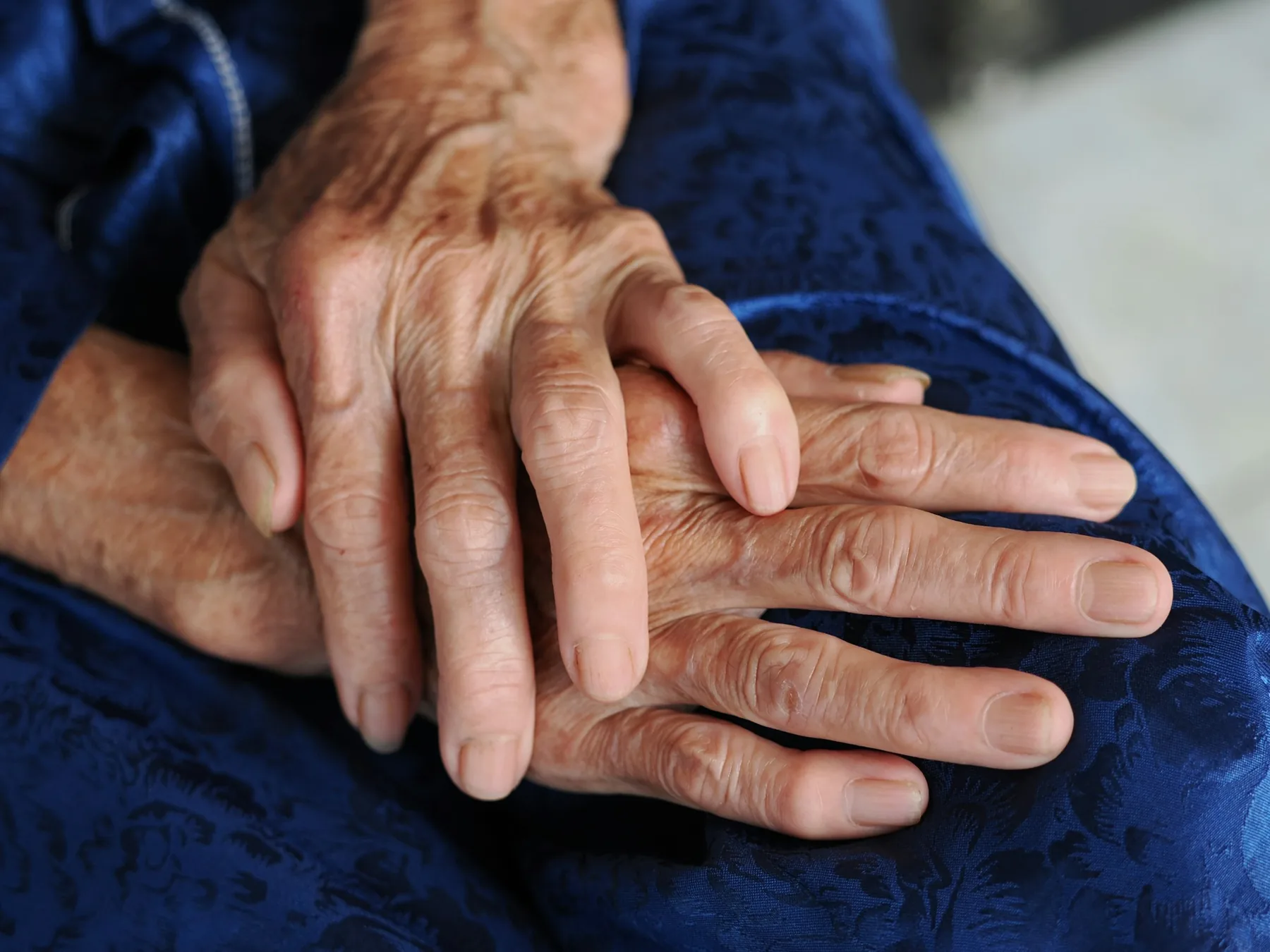 Mains d'une personne âgée – accompagnement et attention